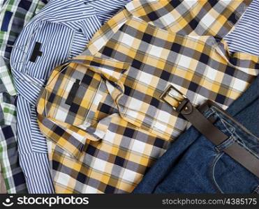 Close up, men&rsquo;s casual patterned shirts and jeans in the same stack