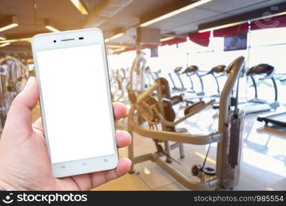 Close-up Men use Hand holding smartphone blurred images touch of Abstract blur of defocused sport gym interior and fitness health club with sports exercise equipment Gym blur background.