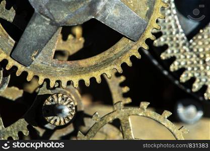 Close up metal gears mechanism. Golden colours. Hard light. Clock interior mechanism parts.