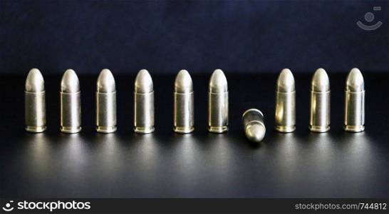 Close up of 9 mm golden pistol bullets ammo on background. Special force units.