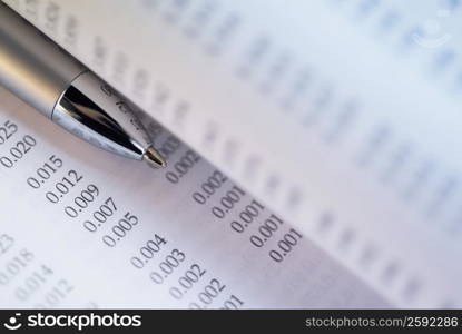 Close-up of a ballpoint pen and stock exchange data