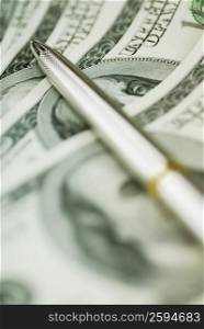 Close-up of a ballpoint pen on dollar bills
