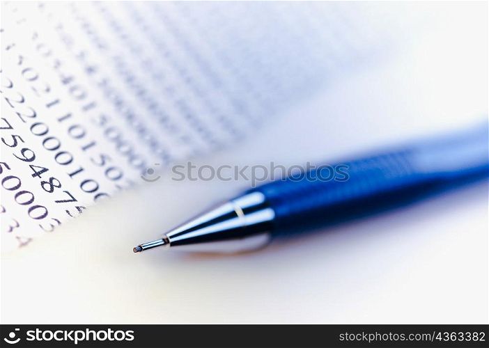 Close-up of a ballpoint pen with a financial document