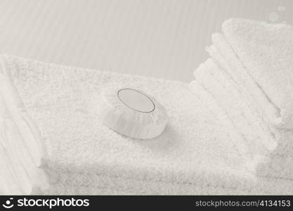 Close-up of a bar of soap on a stack of towels