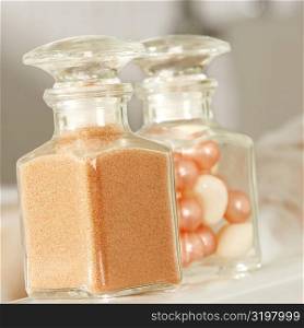 Close-up of a bath powder and bath pearls in glass bottles