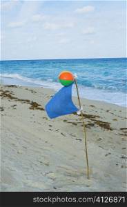 Close-up of a beach ball and a flag on the beach
