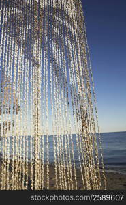 Close-up of a beaded curtain on the beach
