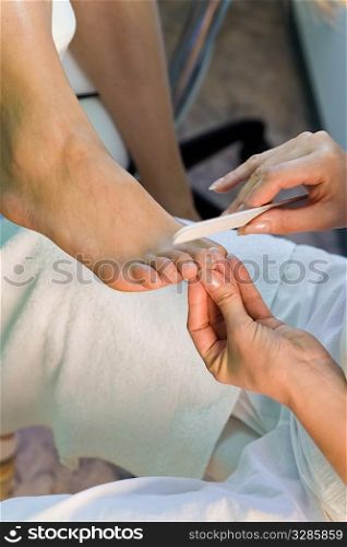 Close up of a beautician giving a pedicure to a client&acute;s feet
