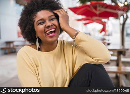 Close-up of a beautiful afro american latin woman smiling and spending nice time at the coffee shop.