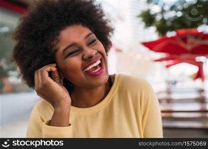 Close-up of a beautiful afro american latin woman smiling and spending nice time at the coffee shop.