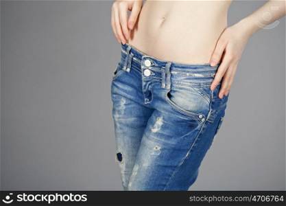 Close up of a beautiful woman wearing jeans isolated on gray background