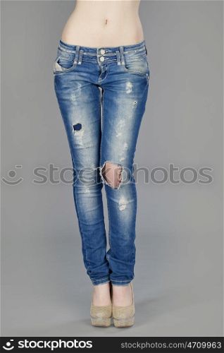 Close up of a beautiful woman wearing jeans isolated on gray background