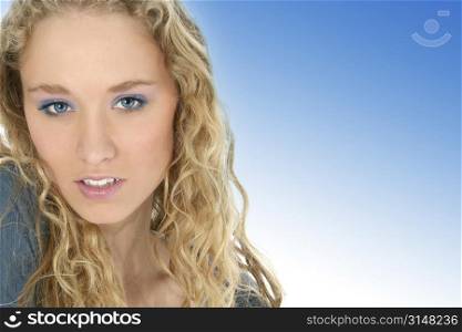 Close up of a beautiful young woman with long curly blonde hair and blue eyes.