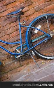Close-up of a bicycle against a brick wall