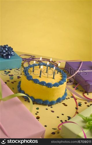 Close-up of a birthday cake and birthday presents on a table