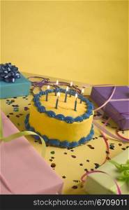 Close-up of a birthday cake and birthday presents on a table
