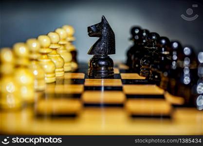 Close up of a black knight and pawns on a chess board