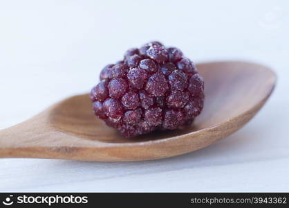 Close-up of a blackberry in a spoon on a table