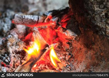 Close up of a bonfire with orange flames and firewood