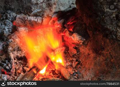 Close up of a bonfire with orange flames and firewood