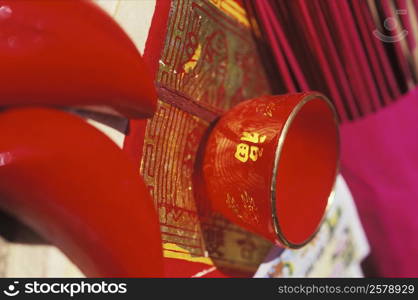 Close-up of a bowl and incense sticks on a mat