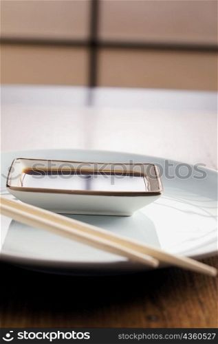 Close-up of a bowl of dip with a pair of chopsticks