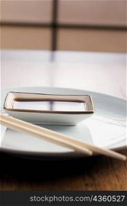 Close-up of a bowl of dip with a pair of chopsticks