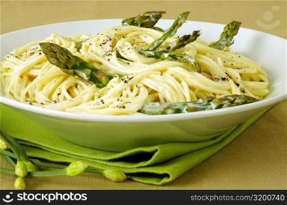 Close-up of a bowl of spaghetti with asparagus