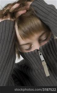 Close-up of a boy&acute;s face covered with a sweater