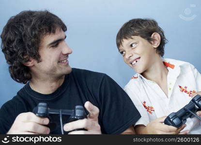 Close-up of a boy and his father playing a video game