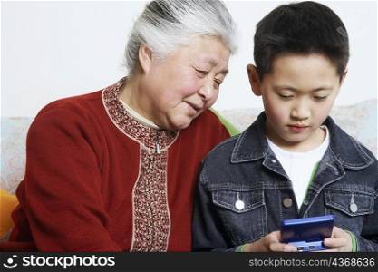 Close-up of a boy and his grandmother playing a video game