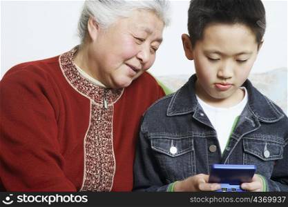 Close-up of a boy and his grandmother playing a video game