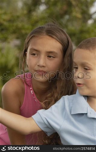 Close-up of a boy and his sister looking sideways