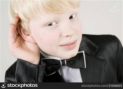 Close-up of a boy covering his ears with his hands