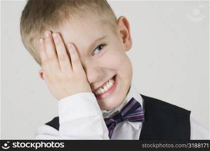 Close-up of a boy covering his eyes with his hands