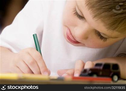 Close-up of a boy drawing on a sheet of paper