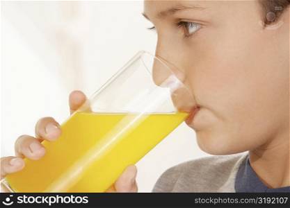Close-up of a boy drinking a glass of juice