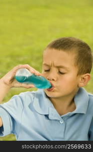 Close-up of a boy drinking beverage from a bottle