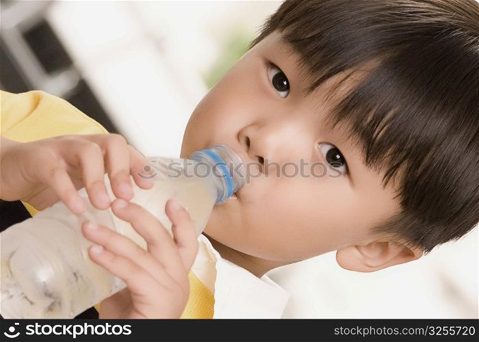 Close-up of a boy drinking water from a water bottle