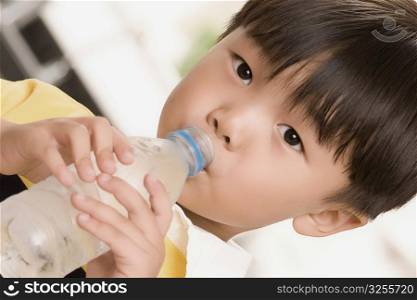 Close-up of a boy drinking water from a water bottle