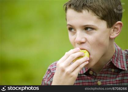 Close-up of a boy eating a fruit