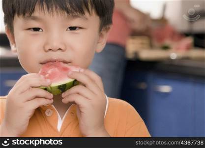 Close-up of a boy eating a slice of watermelon