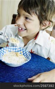 Close-up of a boy eating corn flakes and smiling