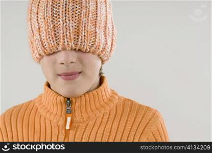 Close-up of a boy hiding his face with a knit hat