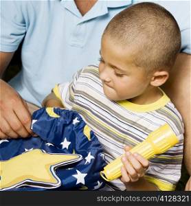 Close-up of a boy holding a flashlight with his father