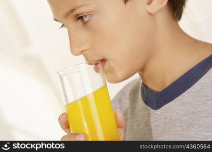 Close-up of a boy holding a glass of orange juice