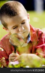 Close-up of a boy holding a magnifying glass