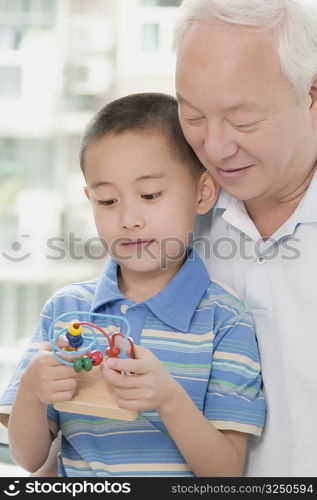 Close-up of a boy holding a toy with his grandfather