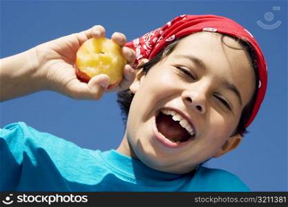 Close-up of a boy holding an apple and smiling