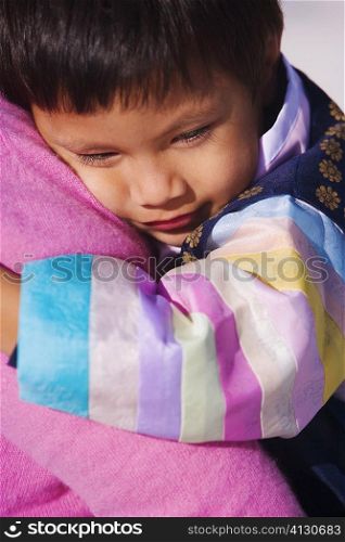 Close-up of a boy hugging a person